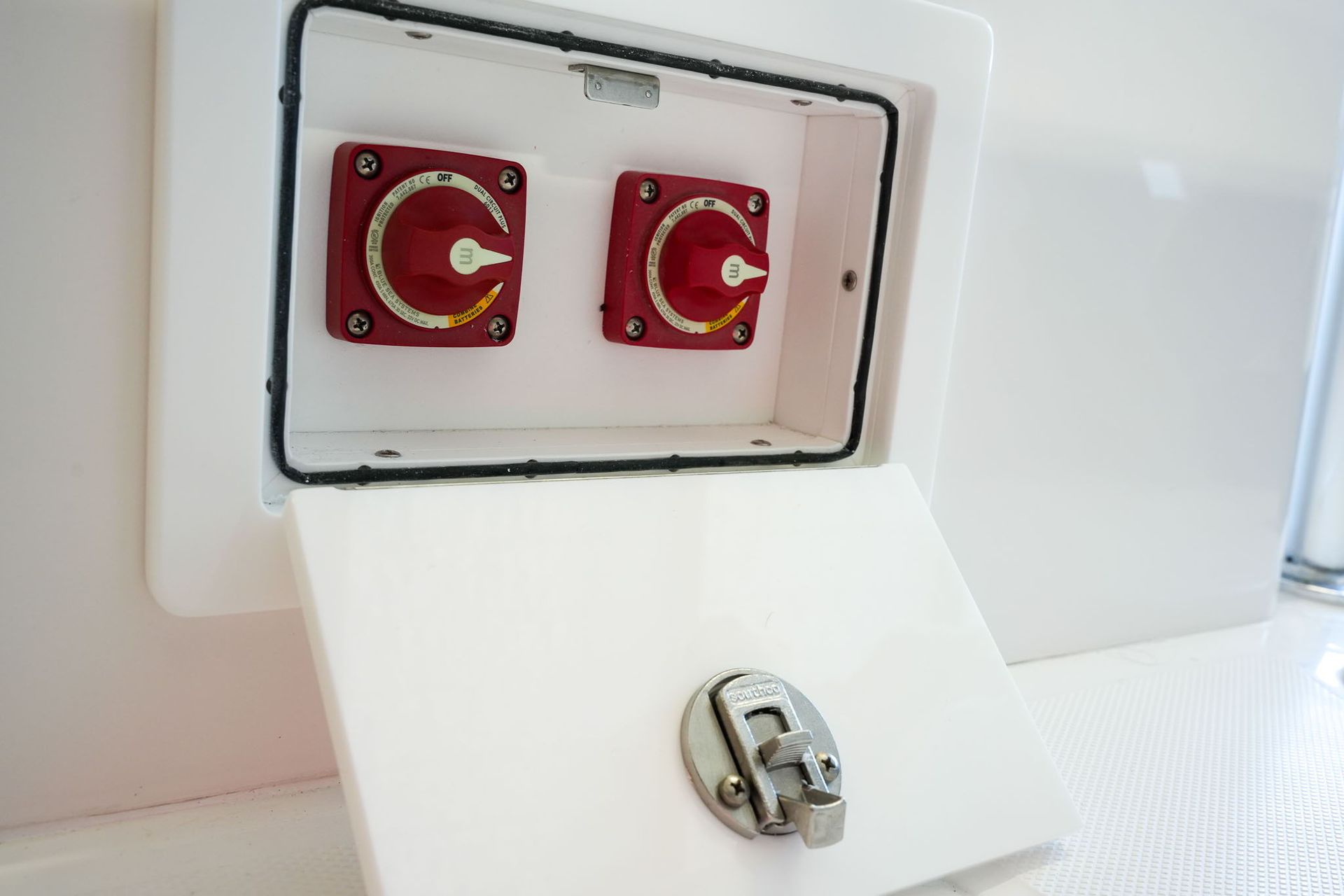 Dashboard of a blue and white boat with gauges, steering wheel, and switches. Falcon Boats logo visible.