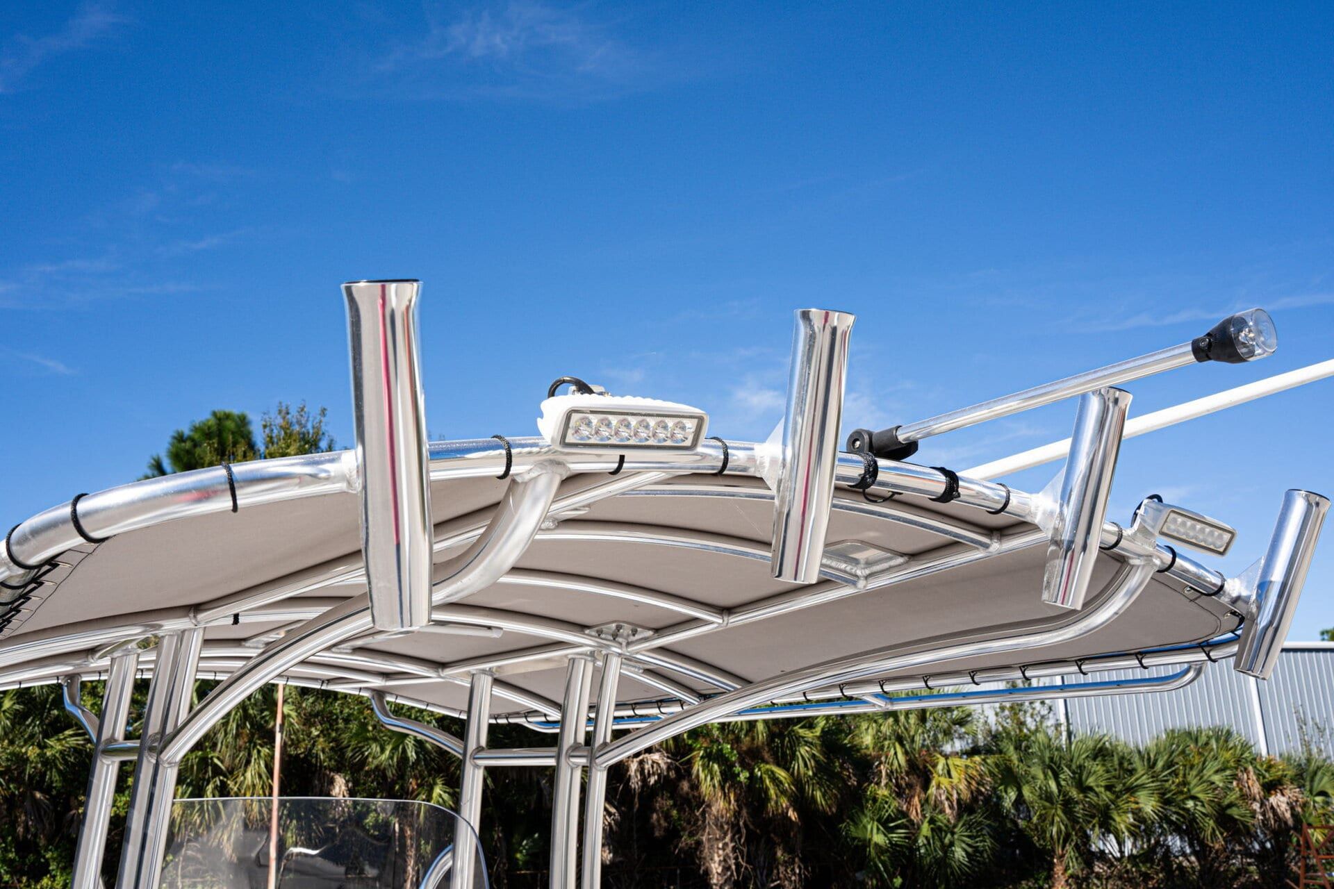 A white and grey fishing boat interior with a center console and seats, viewed from the bow.
