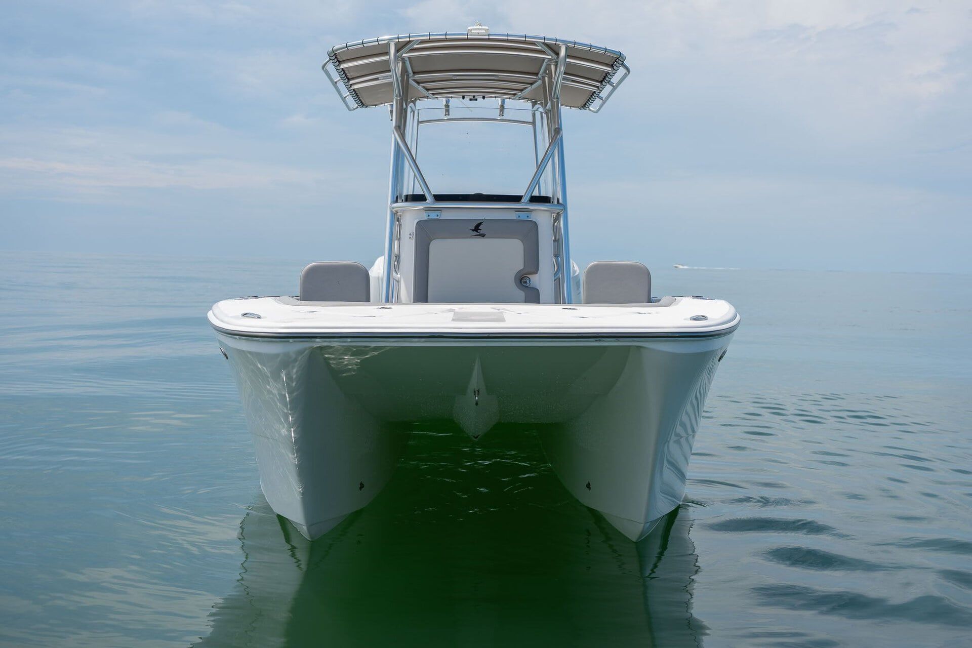 A large, sleek boat on a trailer. The boat has a black and blue design and is in a garage.