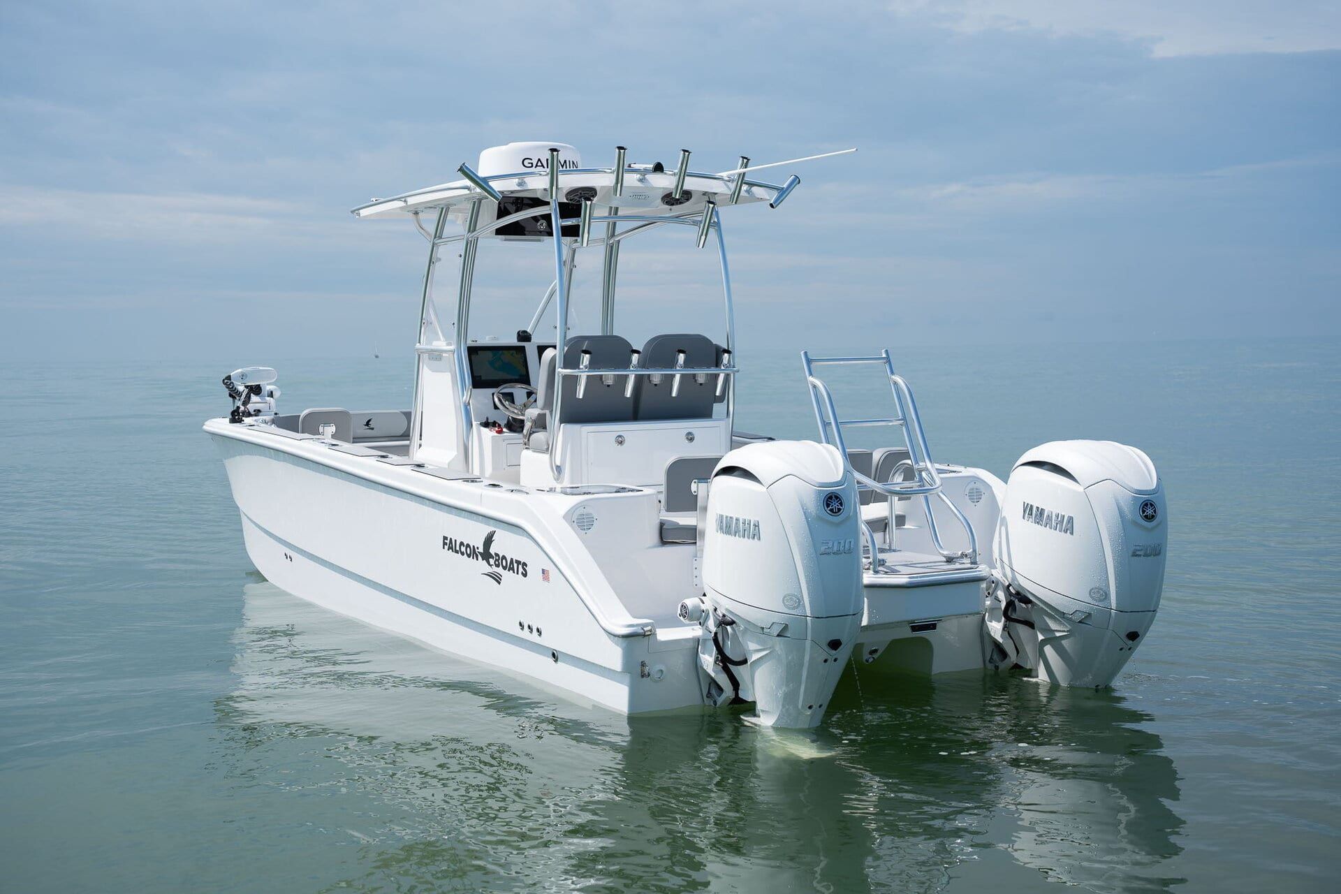A blue motorboat cruising on turquoise water near a waterfront town under a blue sky.