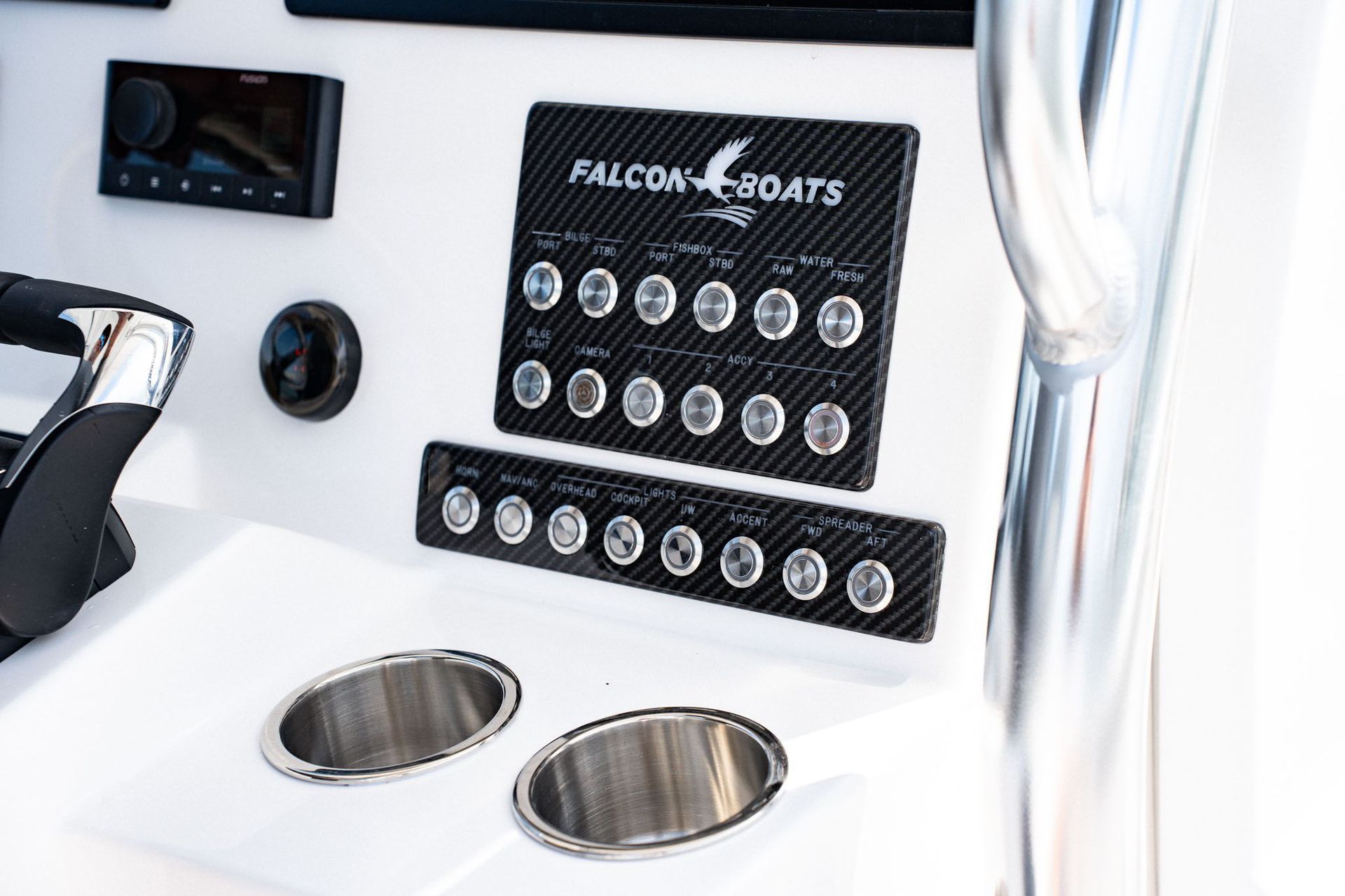 Rear view of a white motorboat with twin Suzuki engines, docked at a pier. Gray cushions and a ladder are visible.