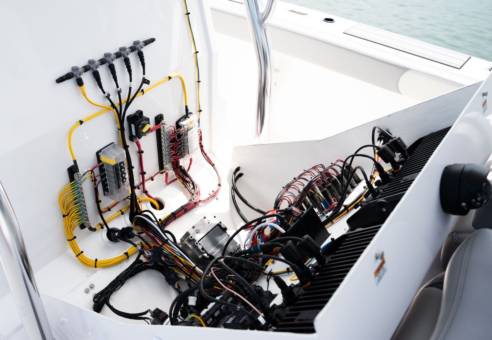 View from the bow of a boat, looking out over water toward a distant shoreline under a cloudy sky.