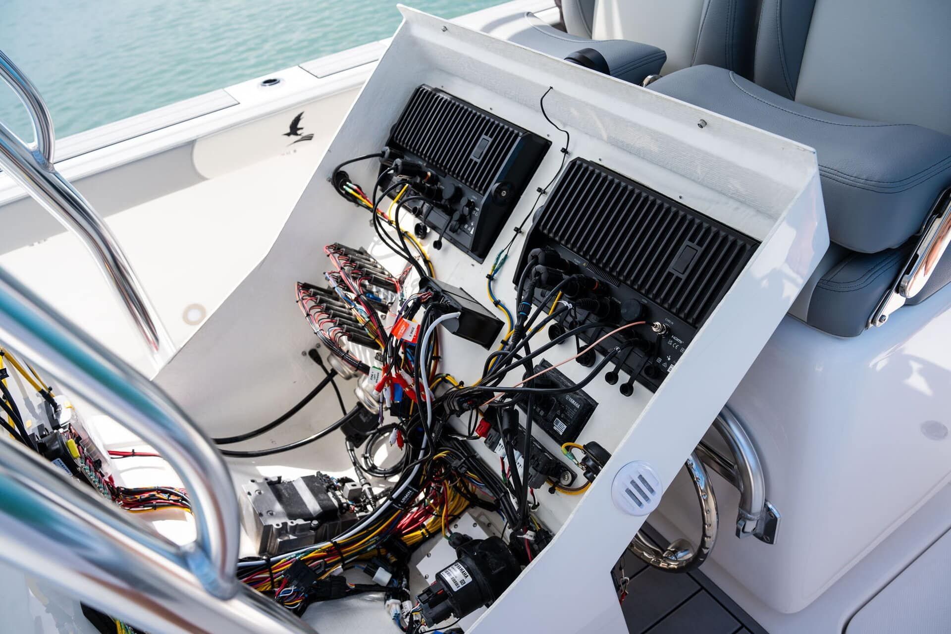 View from a boat's back seating area, facing forward with a clear sky. A white motor and frame are visible.