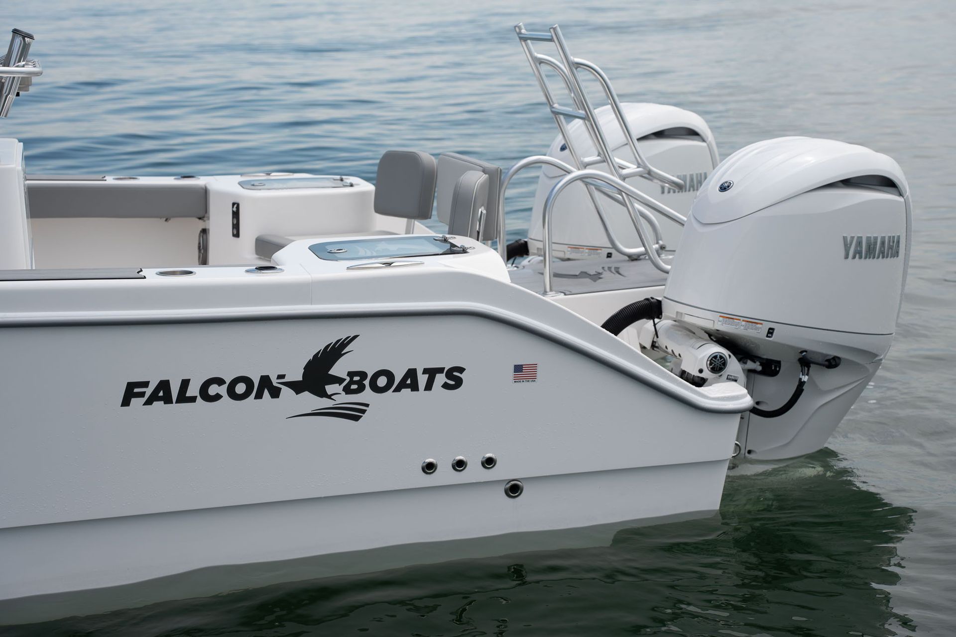 A motorboat with a black Suzuki engine and a sunshade is in shallow, clear water. The boat has blue and gray side stripes.