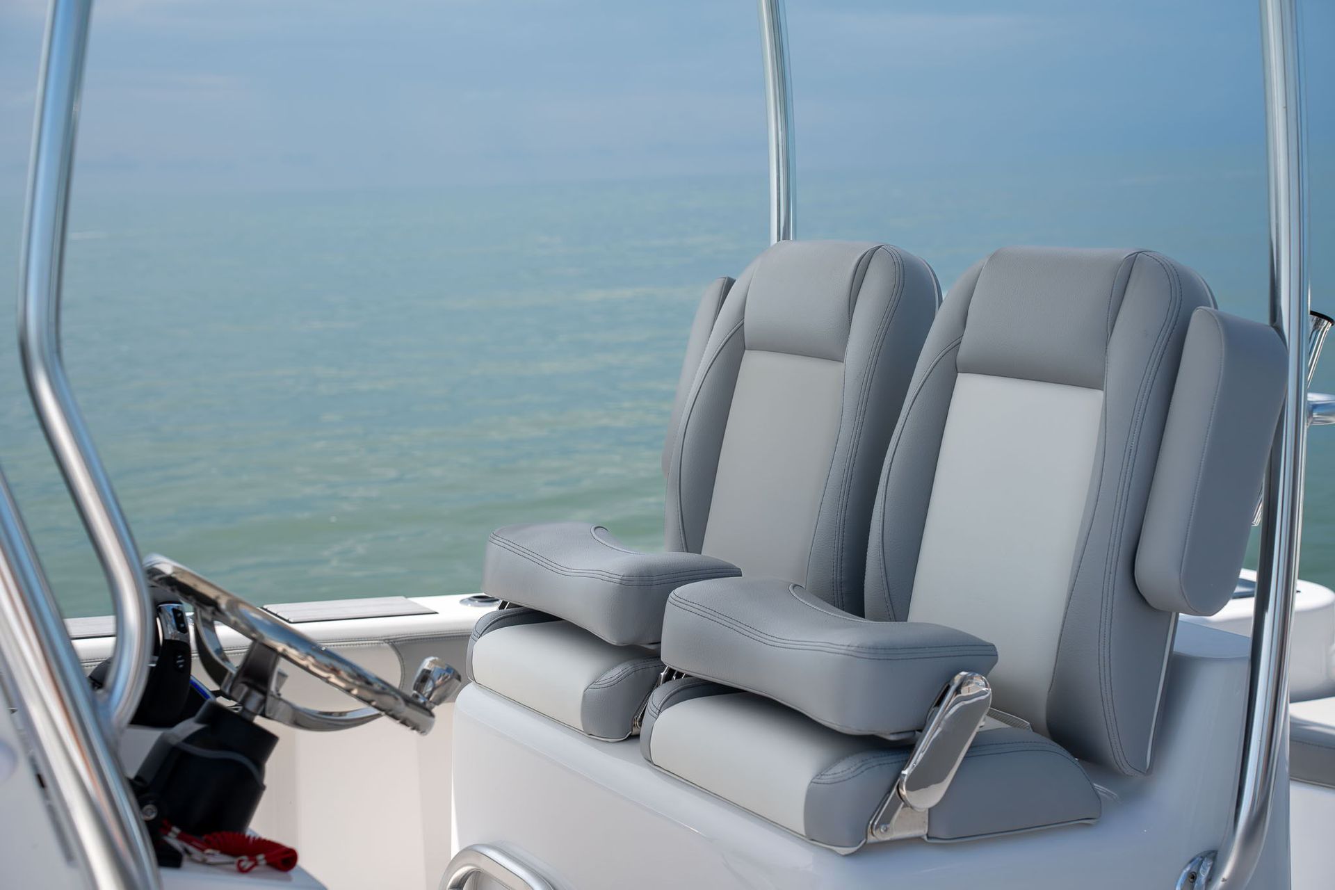 Blue and silver boat console with Garmin display, steering wheel, and Falcon Boats logo.