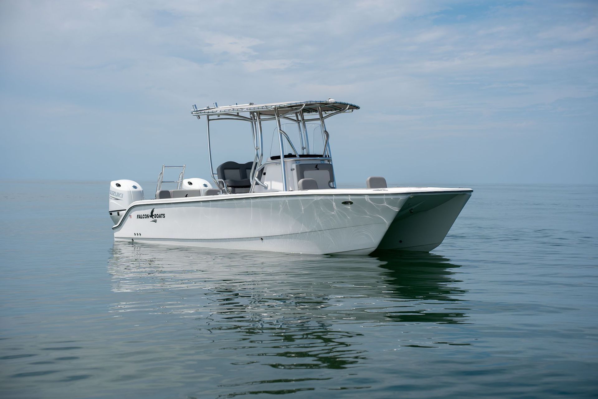 Boat on a trailer inside a building, with a complex black, white, and turquoise graphic on the side.