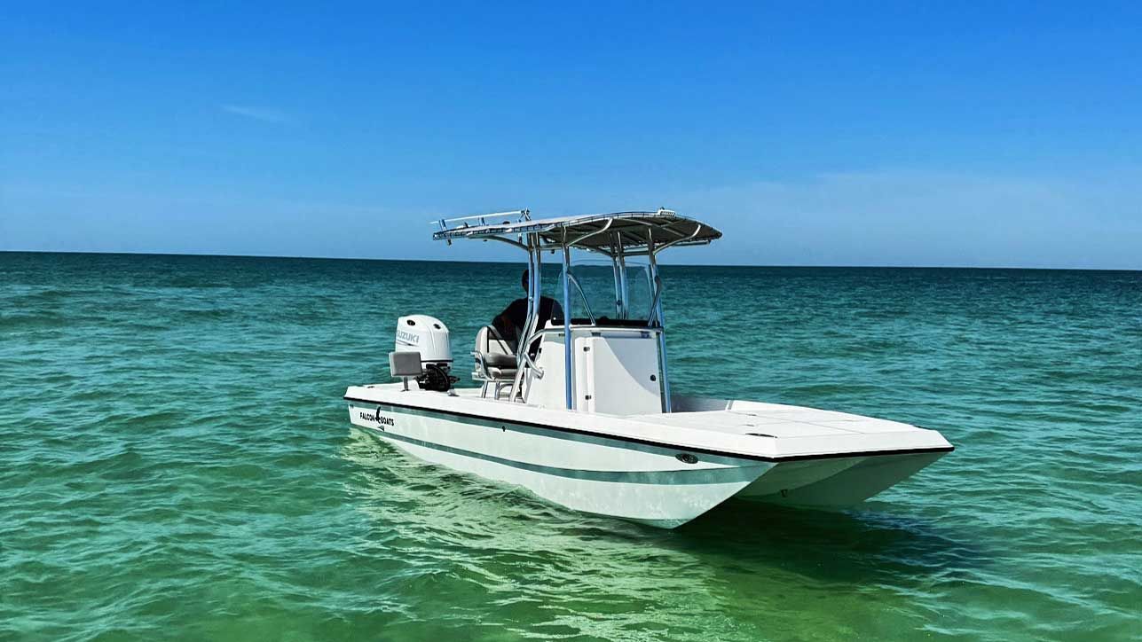 White fishing boat on turquoise water under a clear blue sky.
