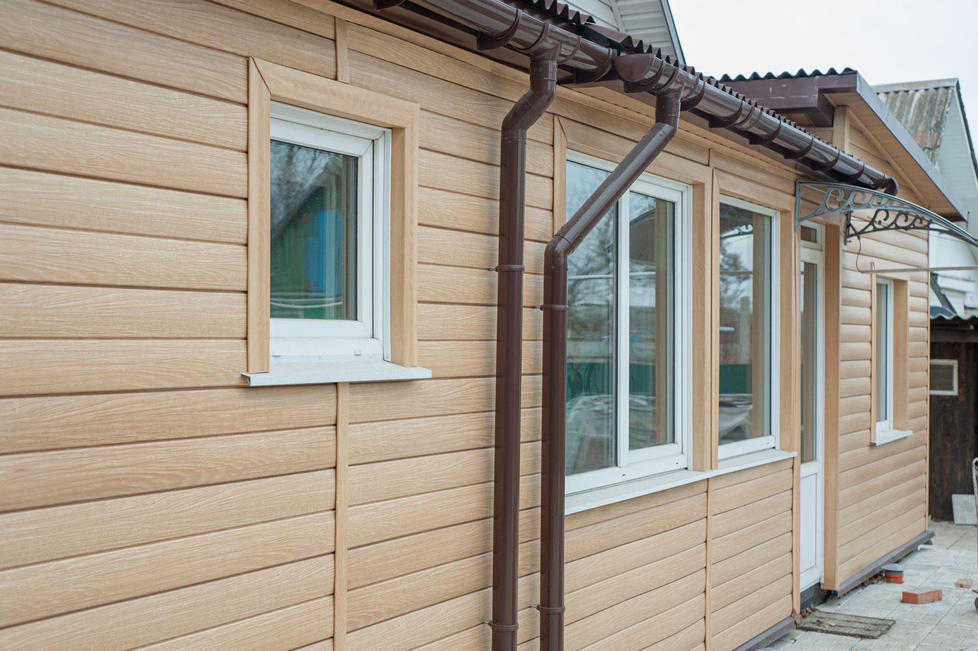 A wooden house with a gutter on the side of it.