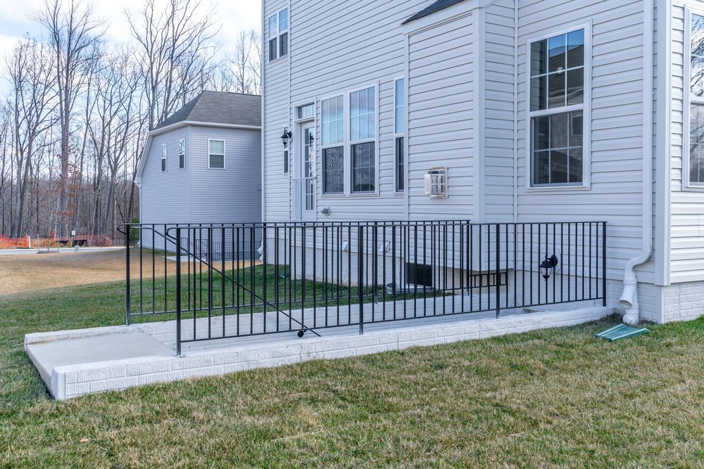 A white house with a metal railing on the side of it.