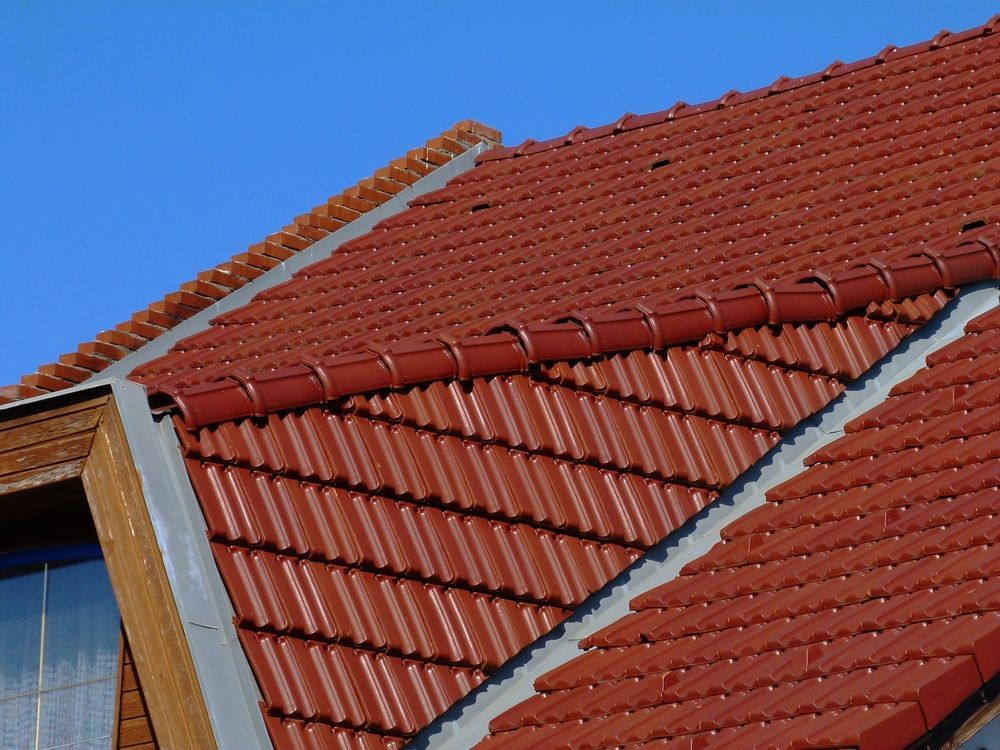 A red tiled roof with a blue sky in the background