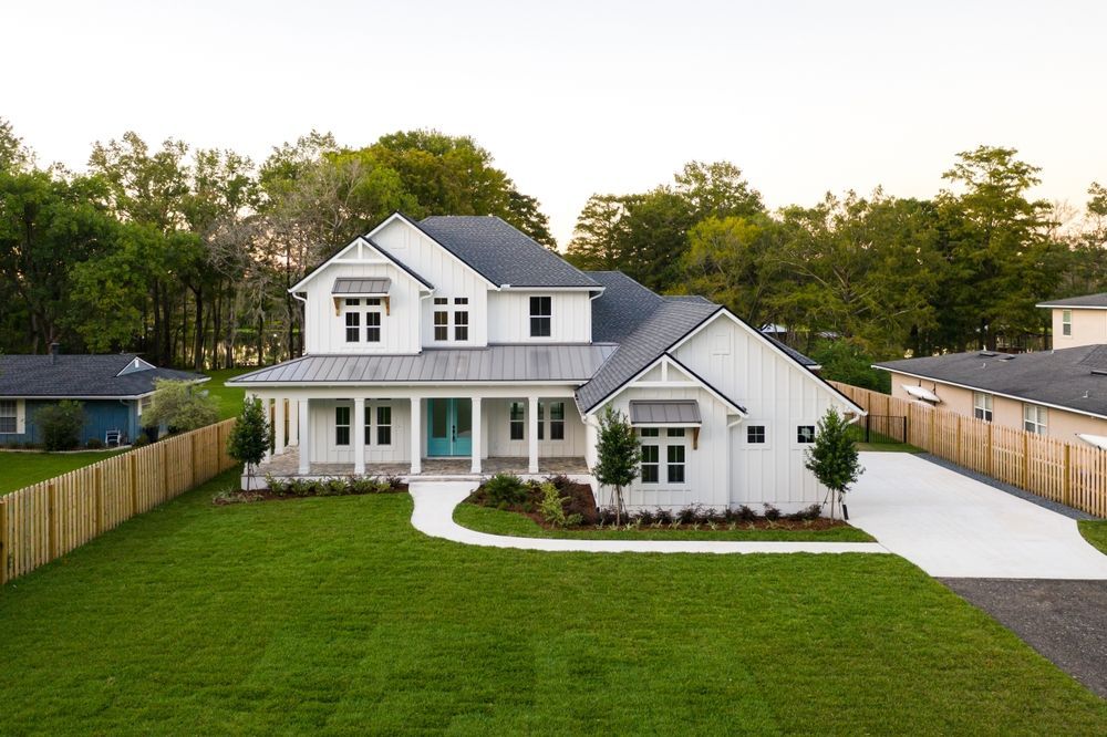 An aerial view of a large white house with a large lawn in front of it.