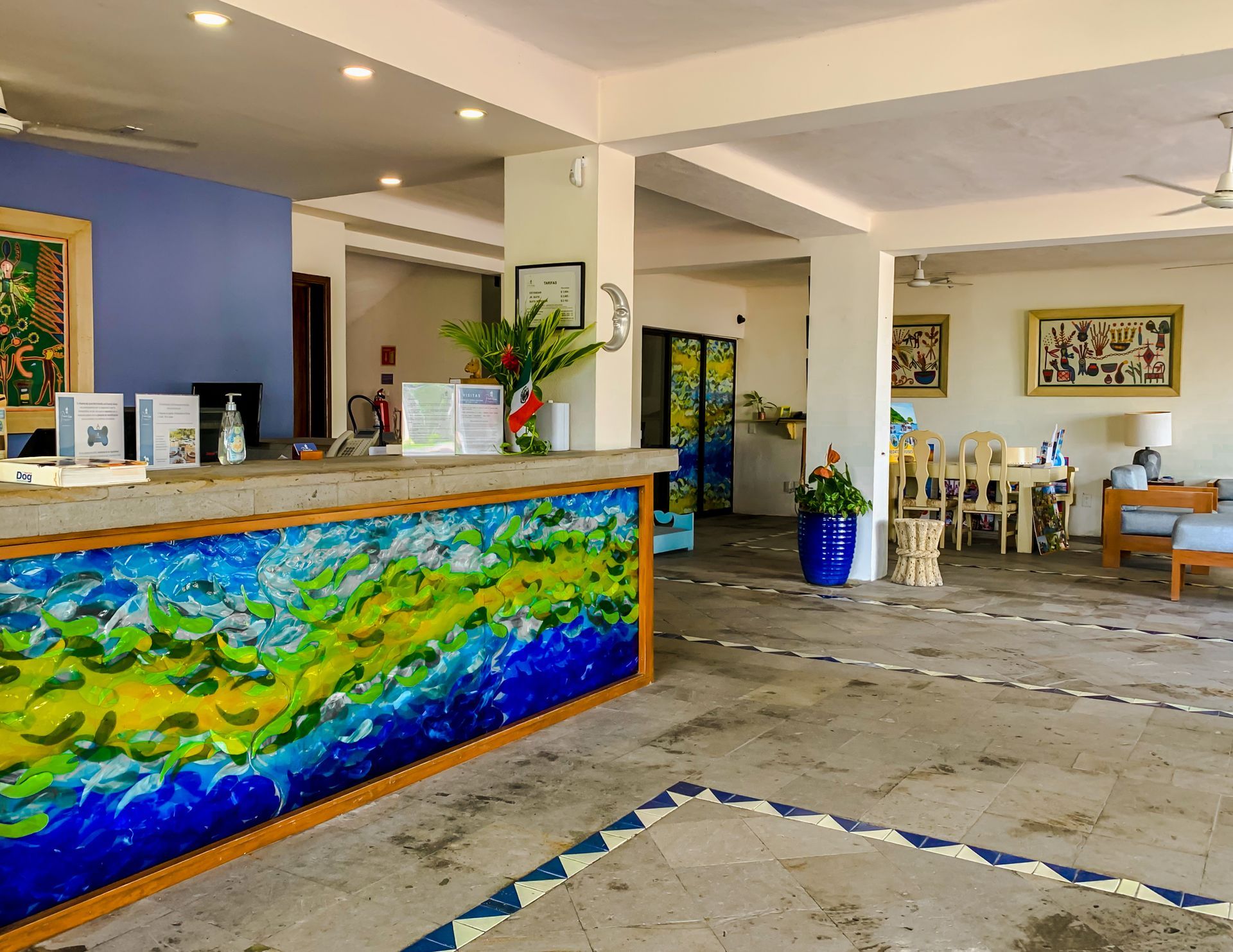 Hotel reception area with a colorful, artistic front desk and seating area.