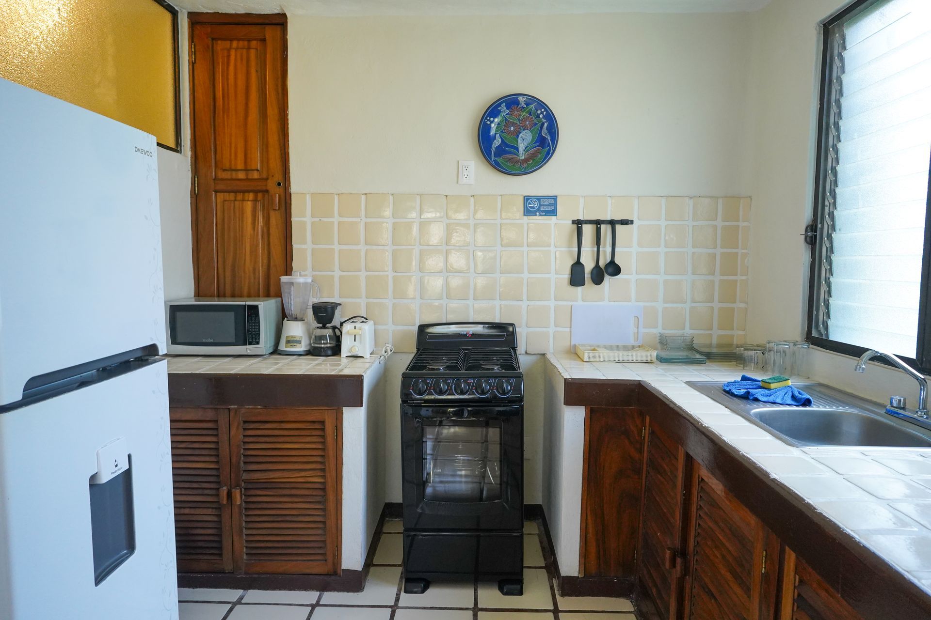 Kitchen with white refrigerator, dark stove, and wooden cabinets.