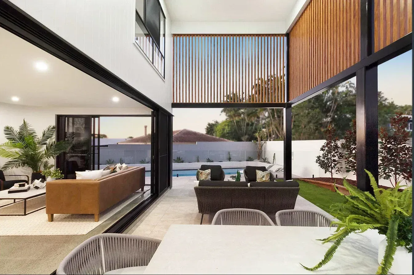 A living room with a couch , table , chairs and a swimming pool.