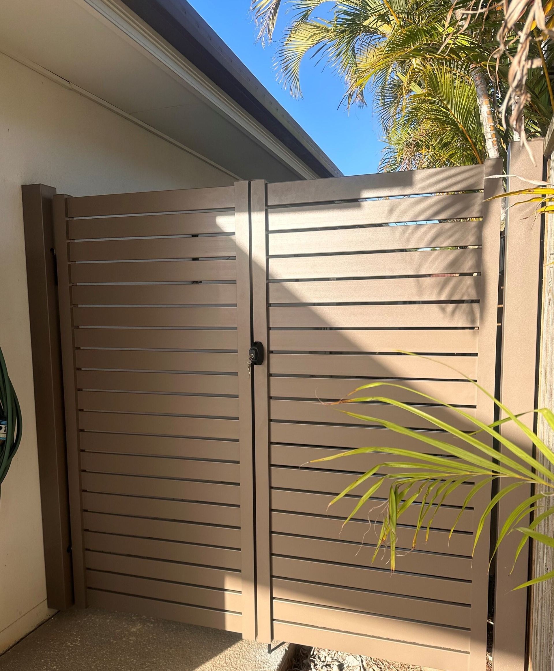A wooden gate is sitting in front of a house.