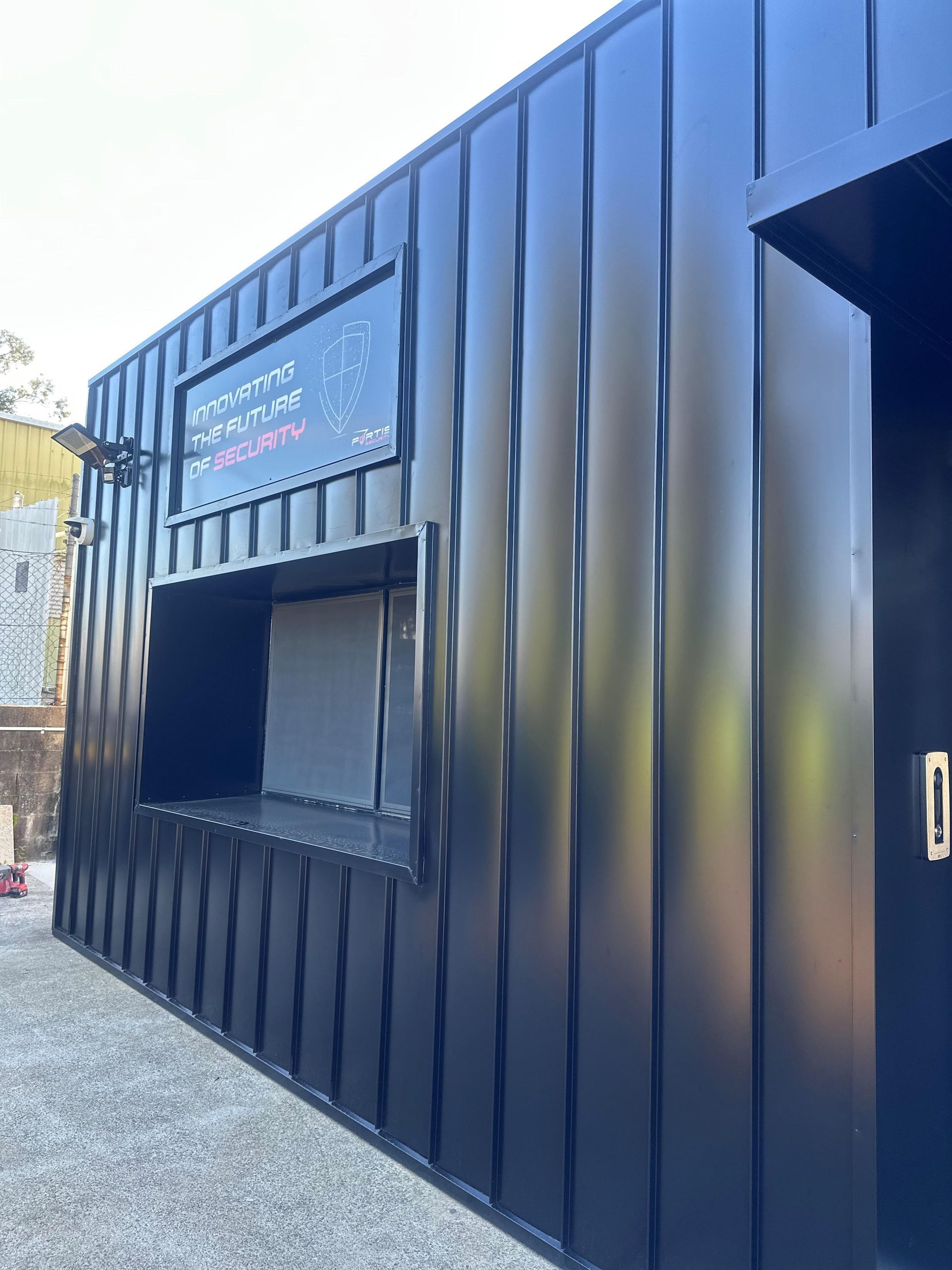 A black building with a window on the side of it.