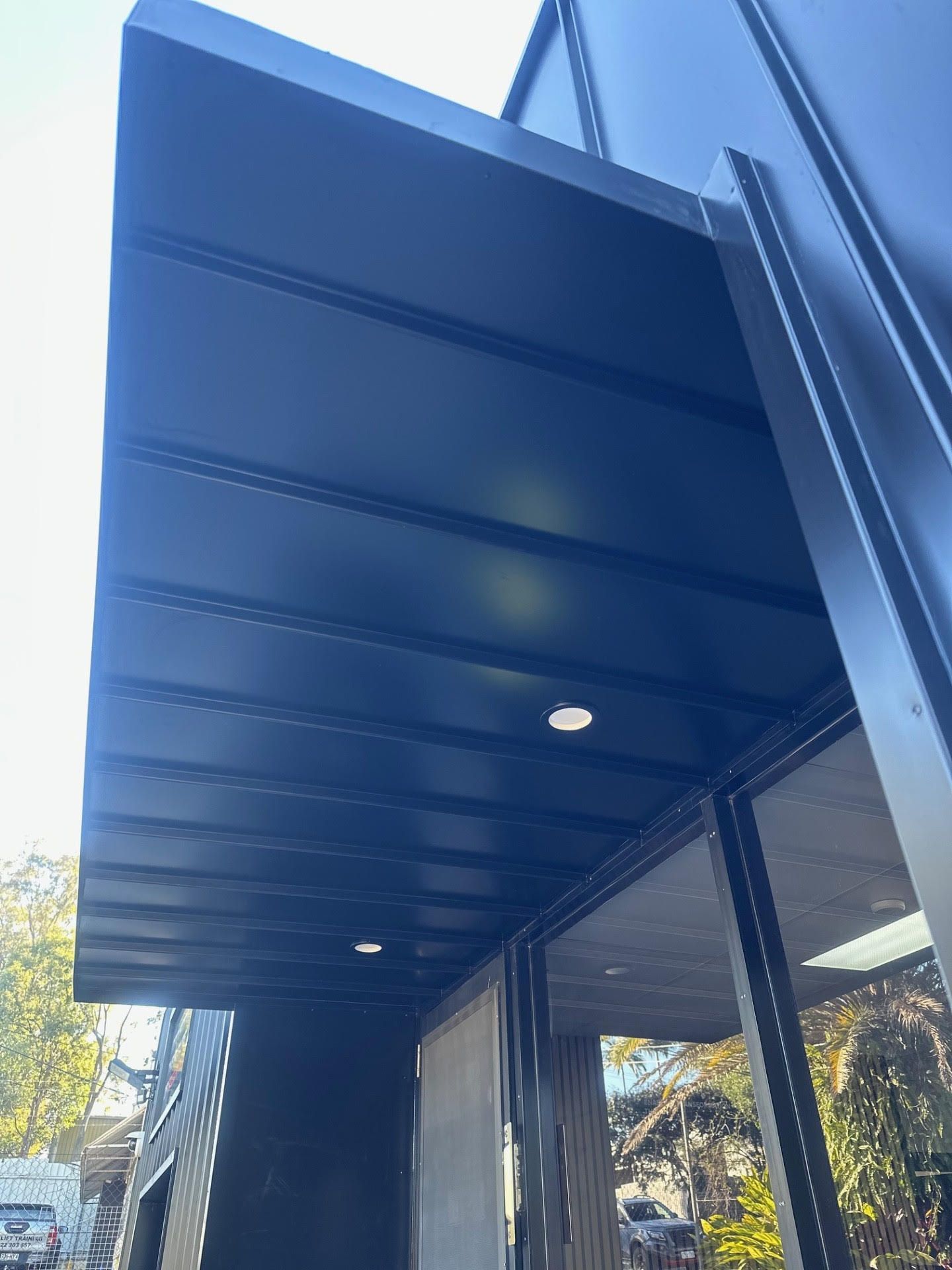 A black awning is on the side of a building.