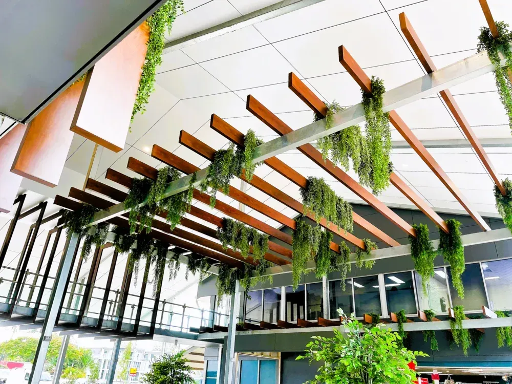 A ceiling with wooden beams and plants hanging from it
