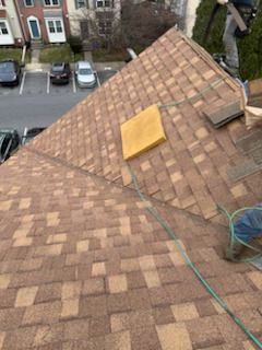 A man is working on the roof of a house.