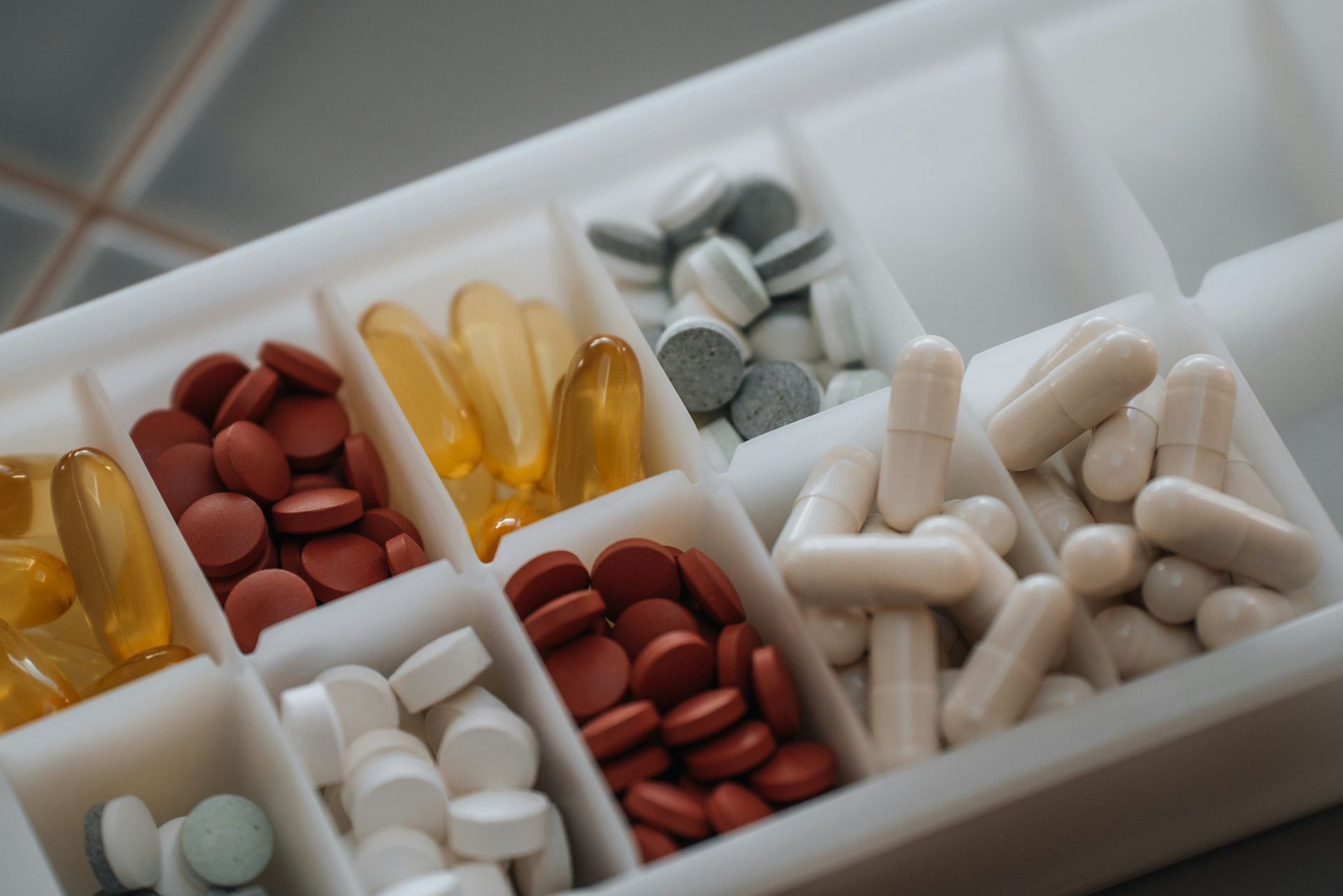 An elderly couple is hugging each other and smiling.