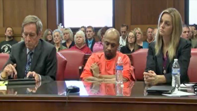 3 people sitting in a courtroom