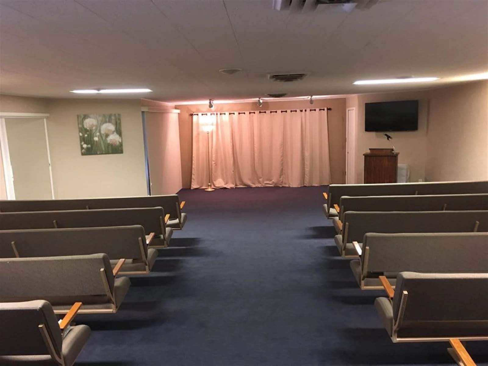 An empty church with rows of seats and a podium