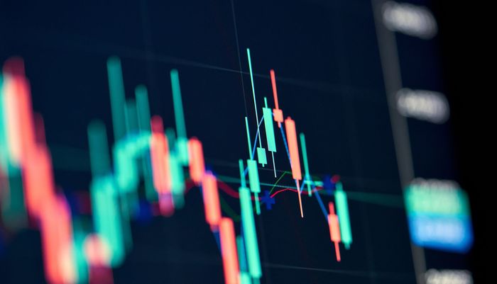 Stock chart displaying a downward trend, with red and green candlestick patterns against a dark background.