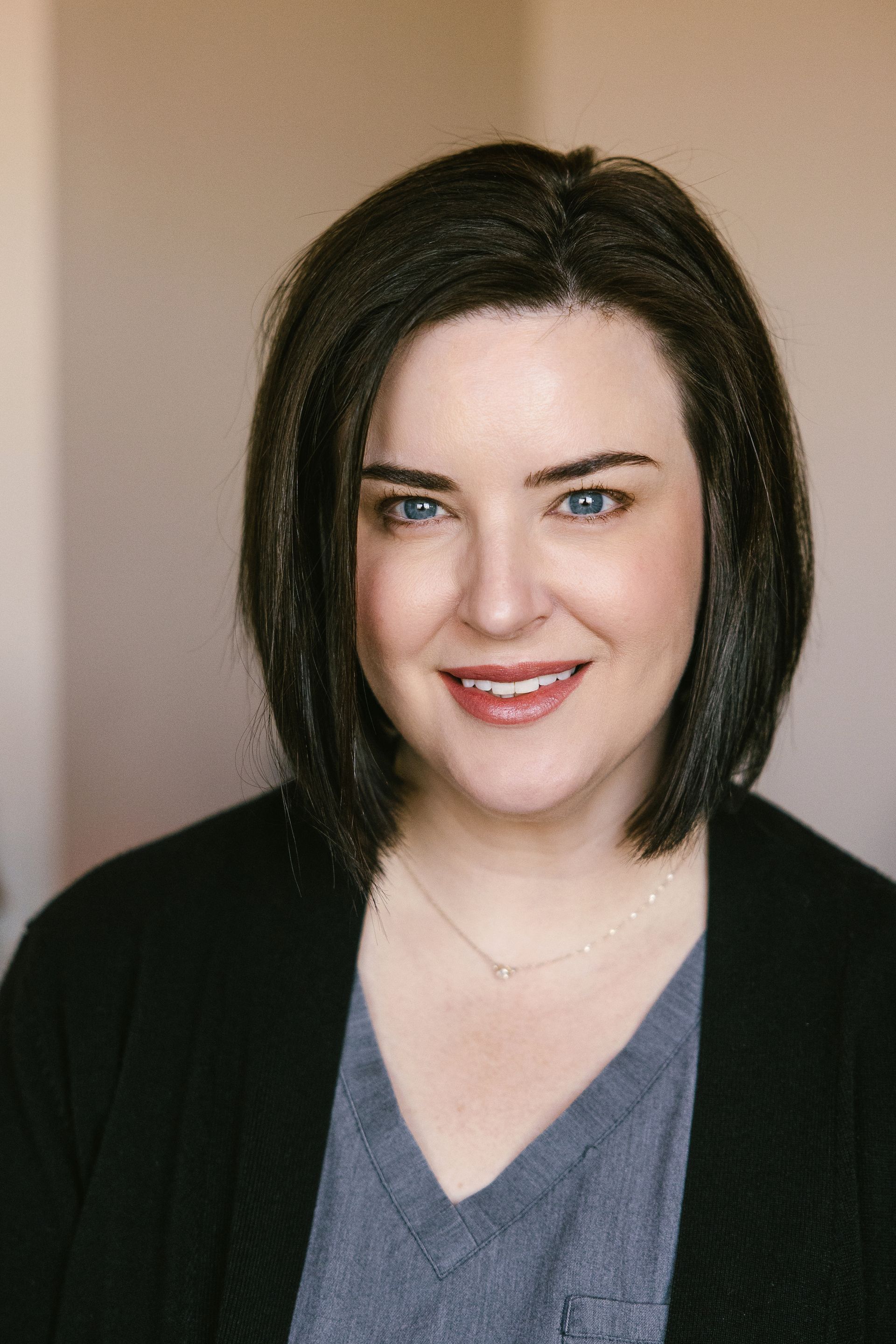 A woman in a purple shirt is smiling for the camera