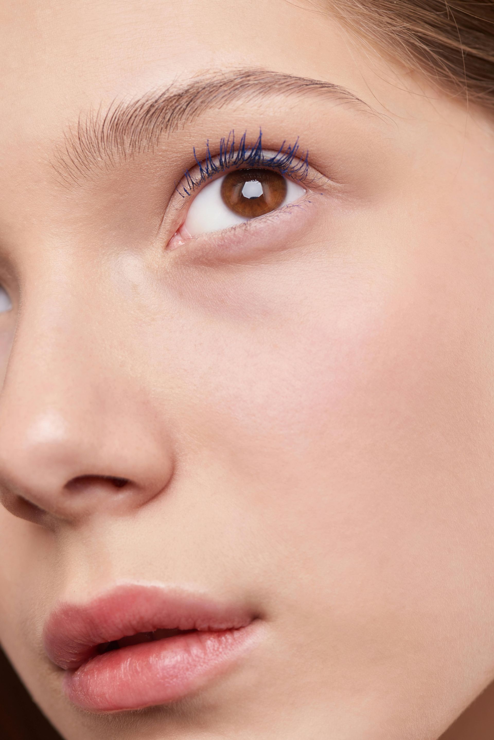 A close up of a woman 's face with mascara on her eyes.