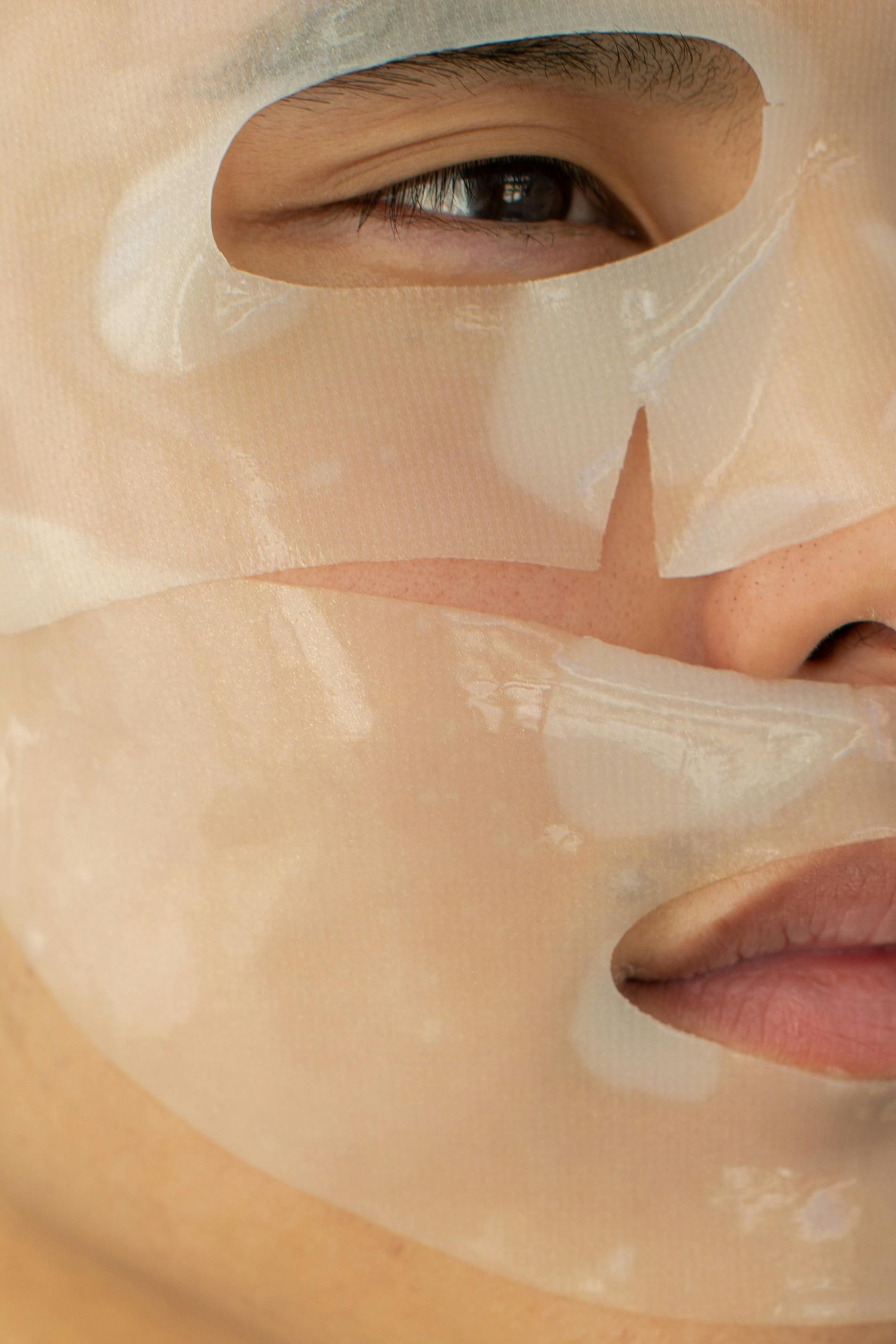 A close up of a person wearing a sheet mask on their face.
