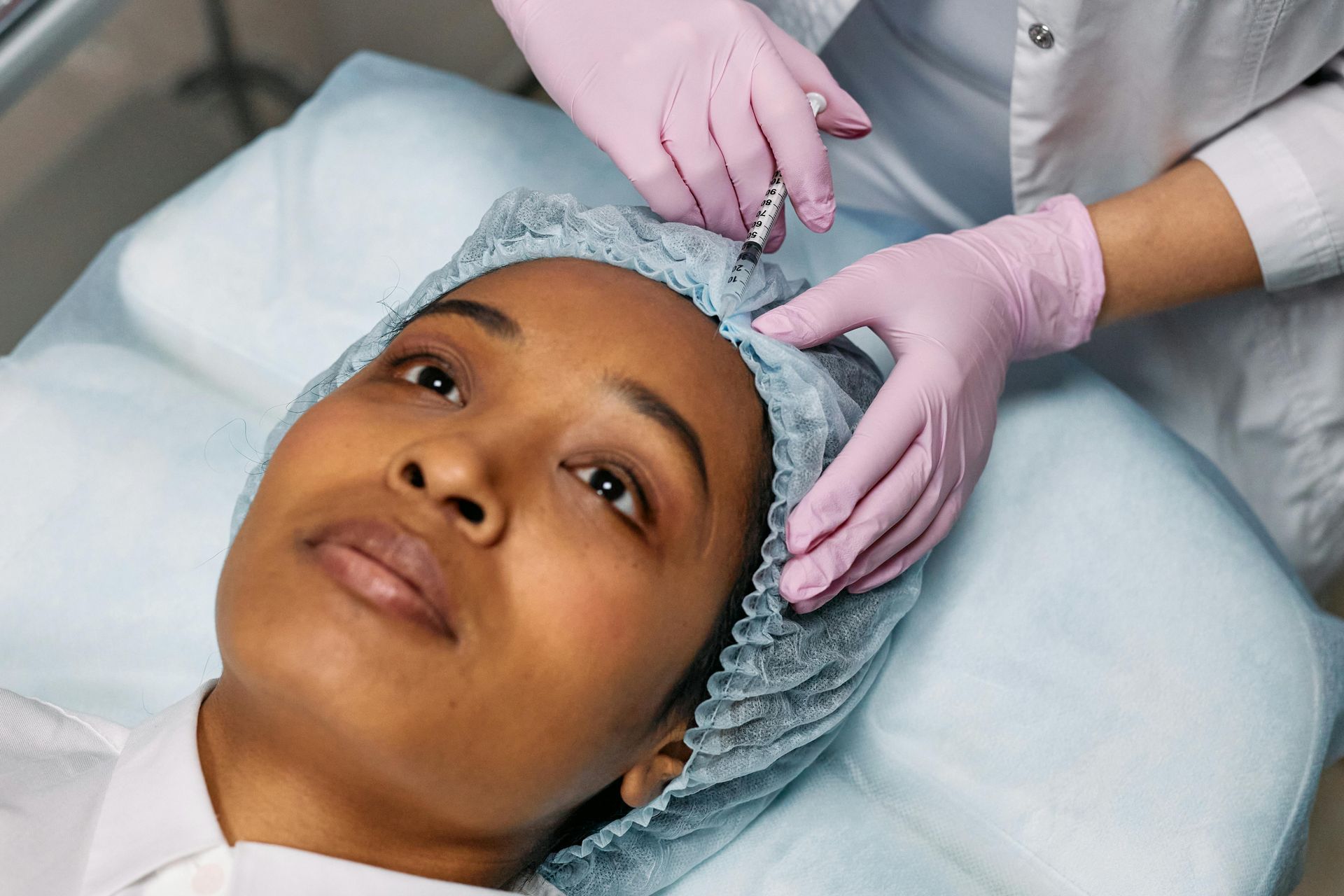 A woman is getting a botox injection in her head.