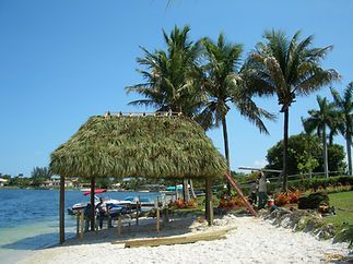 A thatched hut on a beach next to a body of water