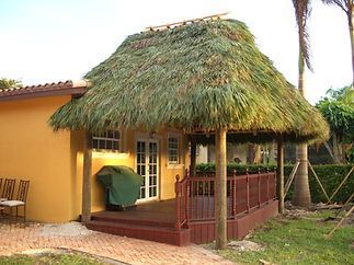 A yellow house with a thatched roof