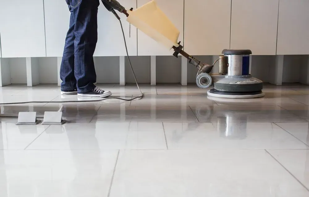 Person Using a Floor Buffer Machine on A Shiny, Tiled Floor — Clean Coast Carpet Cleaning in Port Stephens, NSW