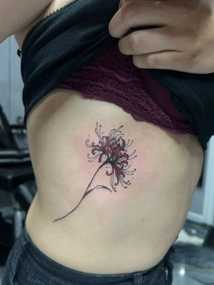 Man's back with a large black mandala tattoo covering most of it, descending to a spine design.