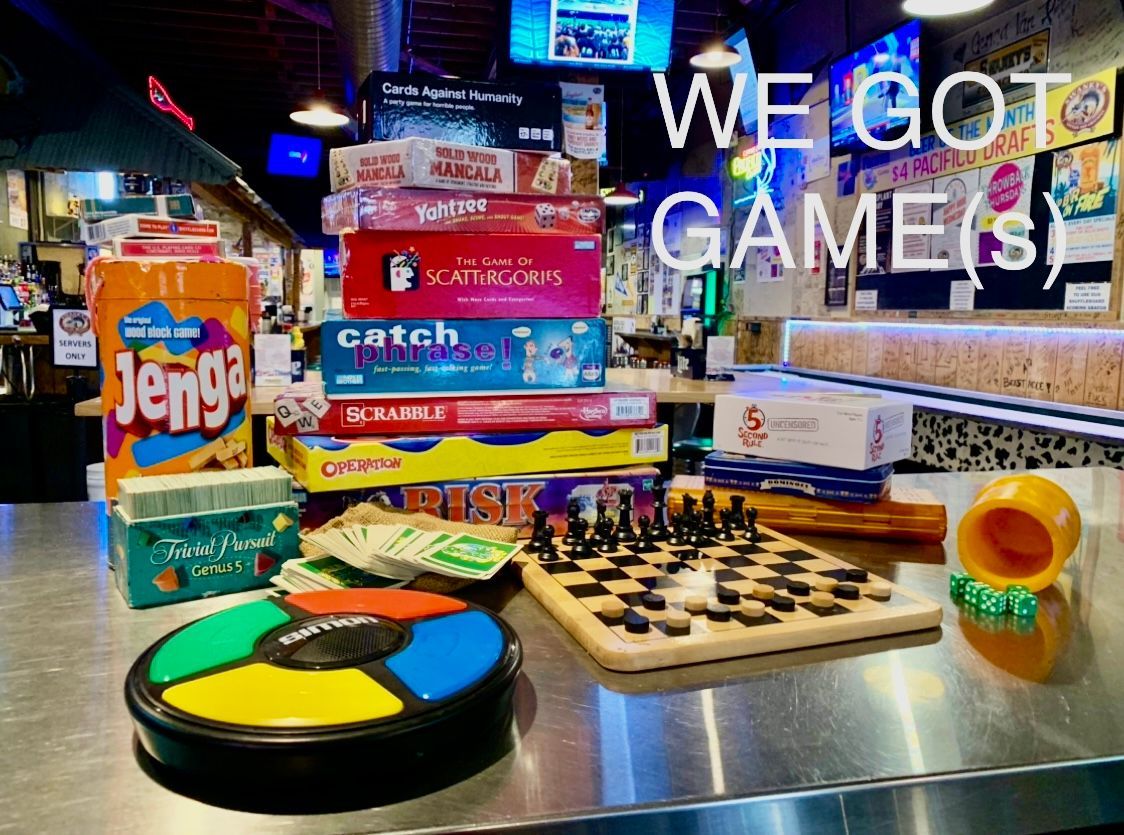 A stack of board games sitting on top of a metal table.