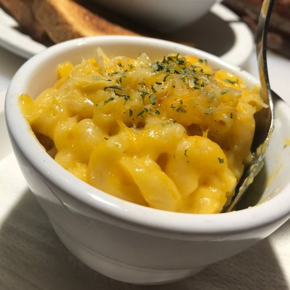 A bowl of macaroni and cheese with a spoon in it