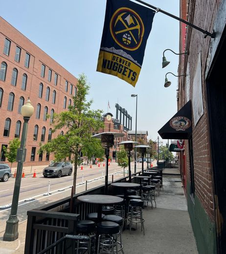 A sign for the denver nuggets hangs from the side of swankys.  a bar for wisconsin and midwest sports fans in denver colorado