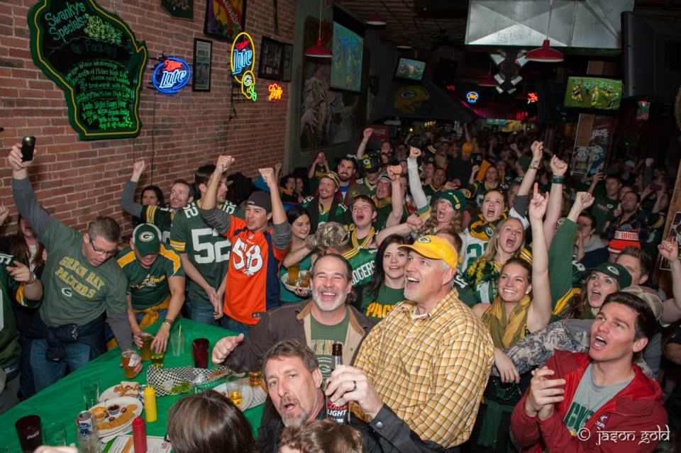 A crowd of people are watching a football game in swankys, denver's #1 midwest sports bar 