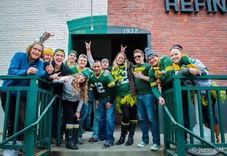 A group of people are posing for a picture in front of swankys, denver's #1 midwest sports bar 