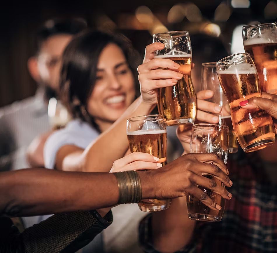 A group of people are toasting with beer glasses