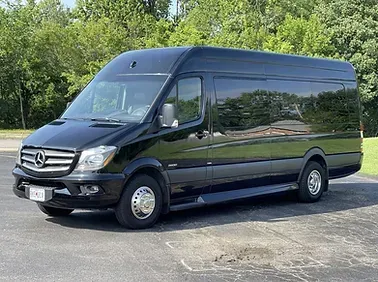 A black mercedes sprinter van is parked in a parking lot.