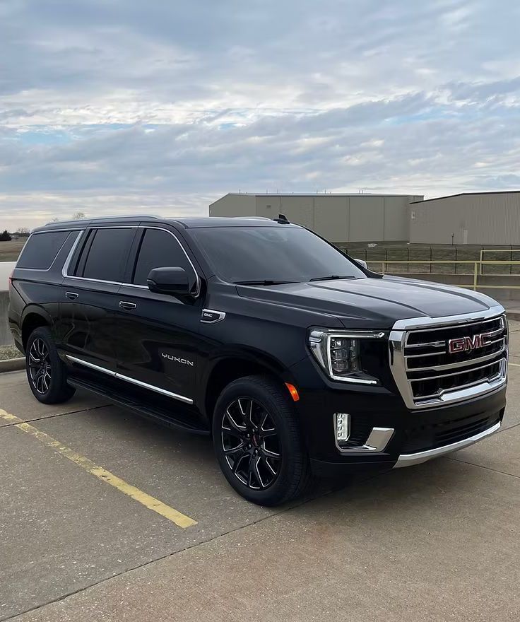 A black suv is parked in a parking lot.