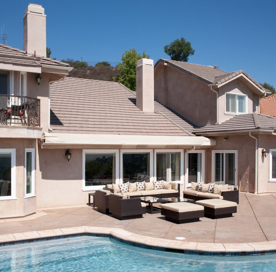 A large house with a swimming pool in front of it