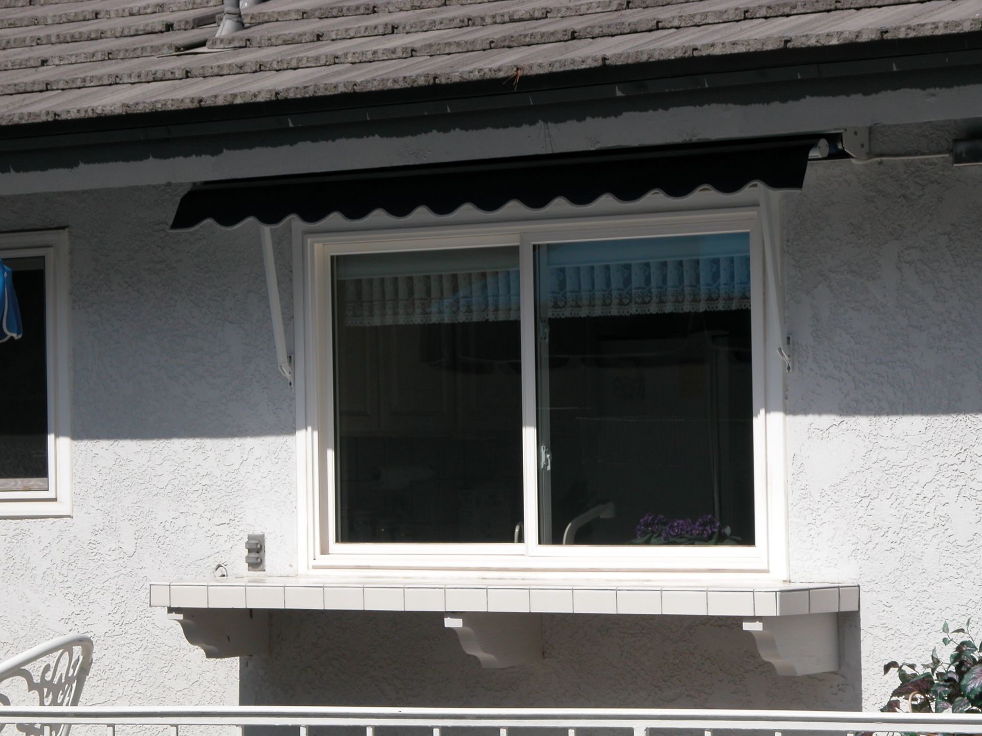 A white window with a black awning over it