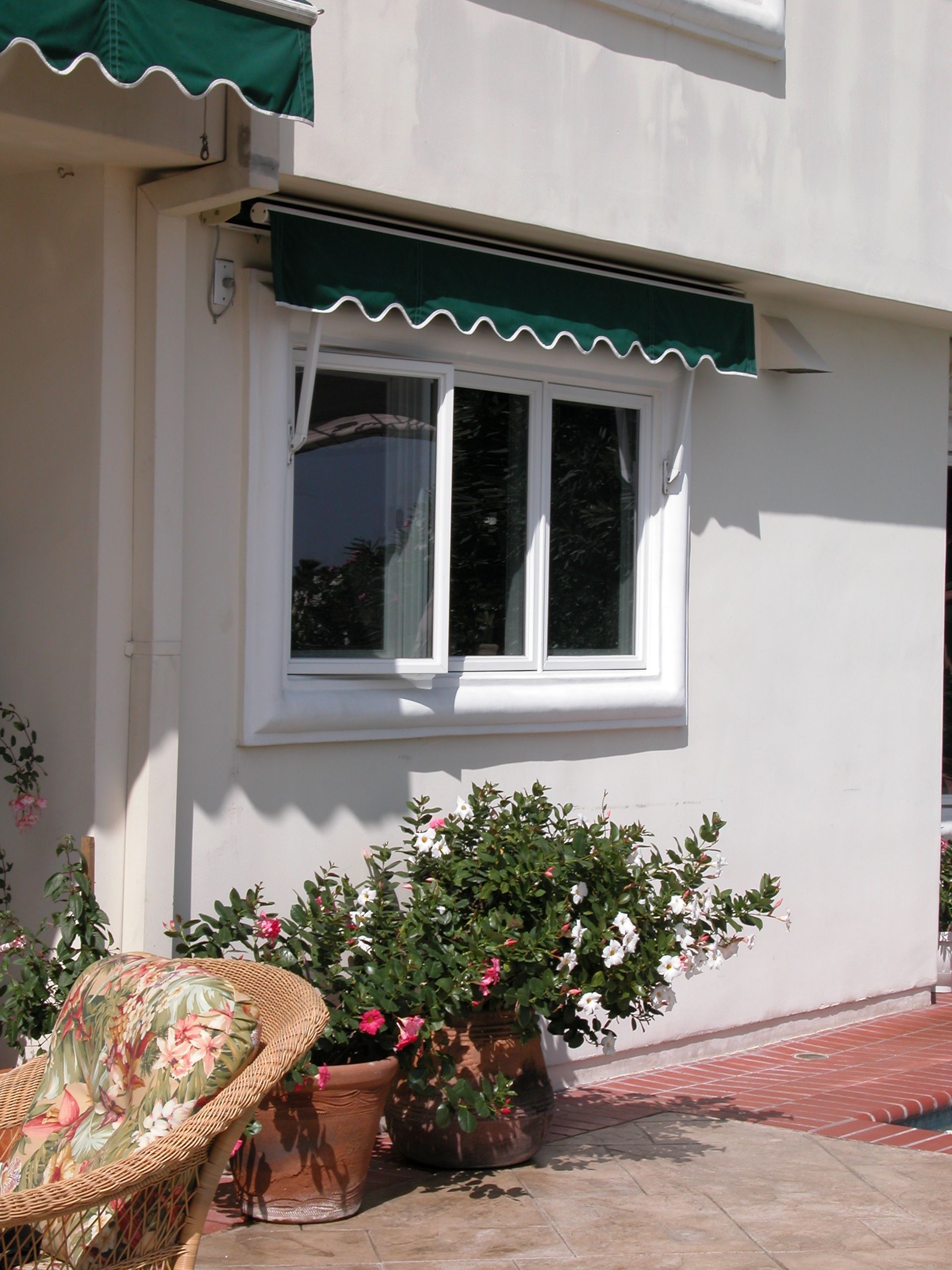 A white house with a green awning over a window