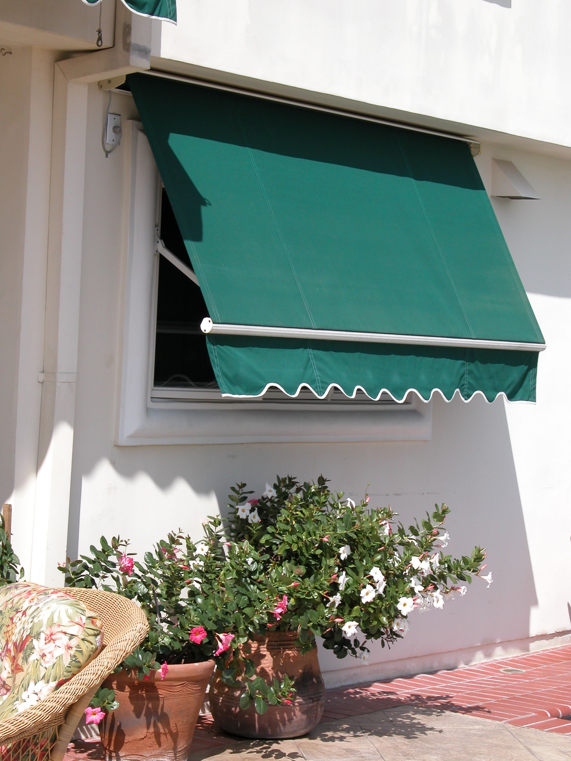 A white building with a green awning on the window