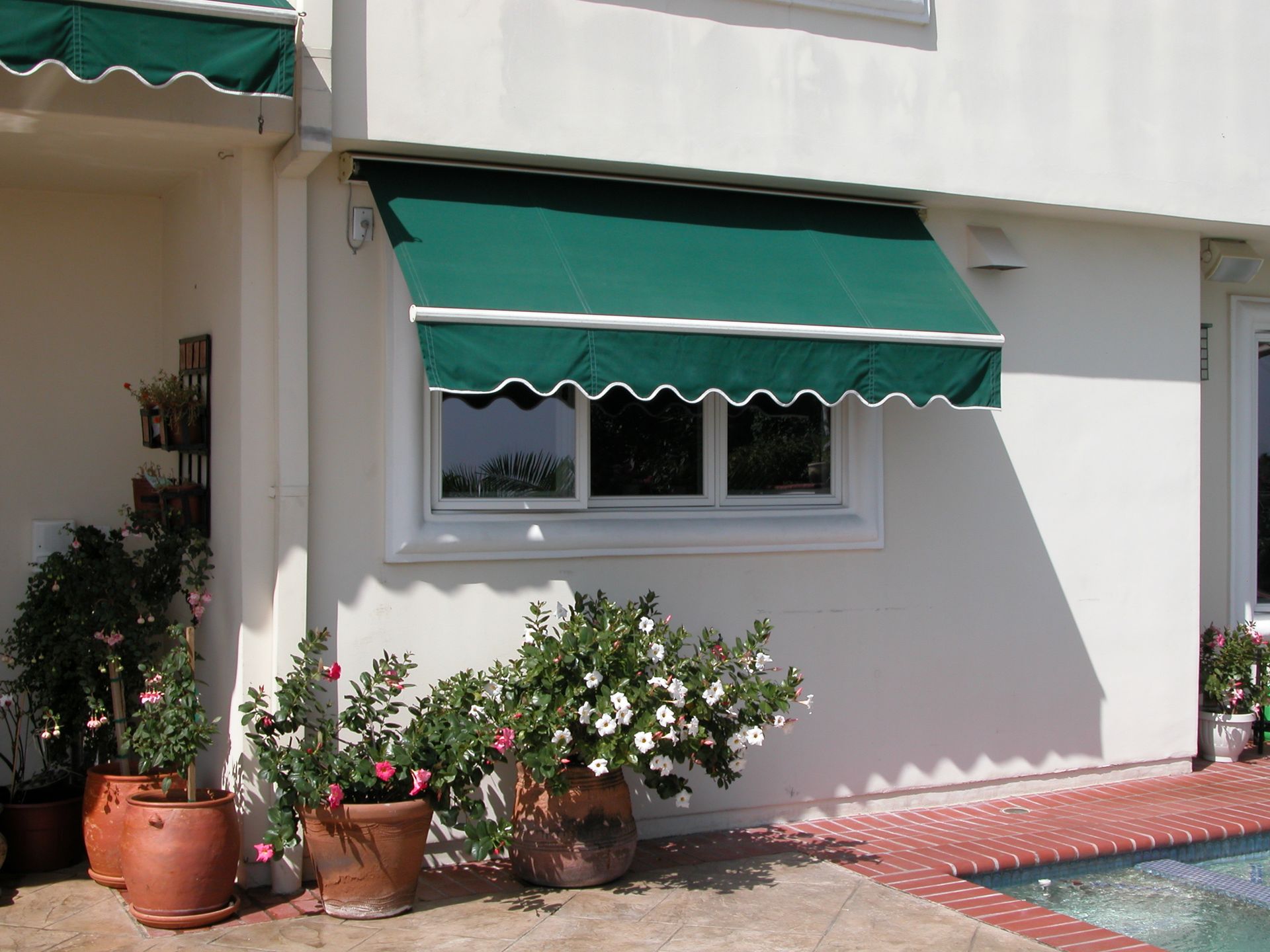 A white house with a green awning over a window