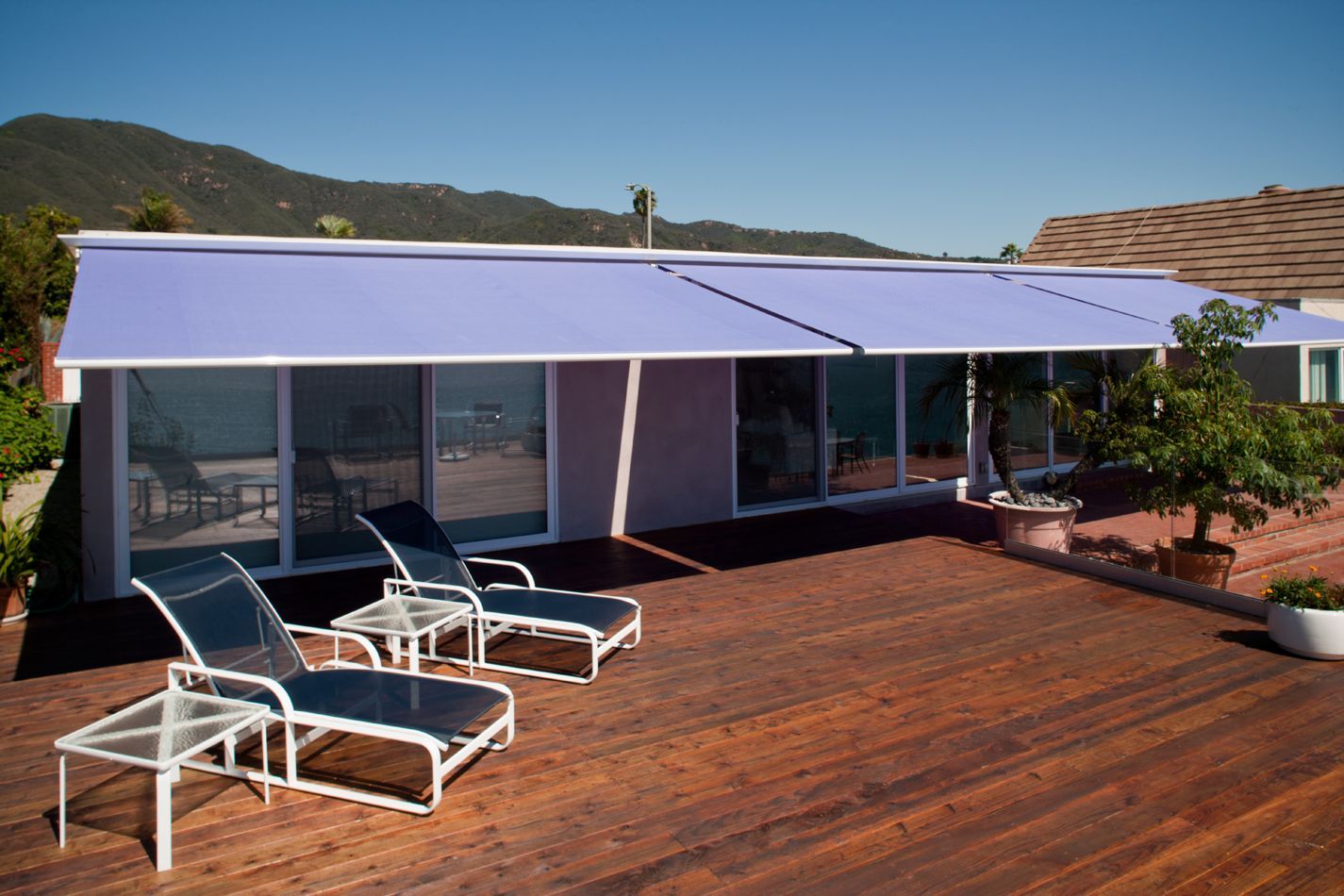 A house with a purple awning and a wooden deck