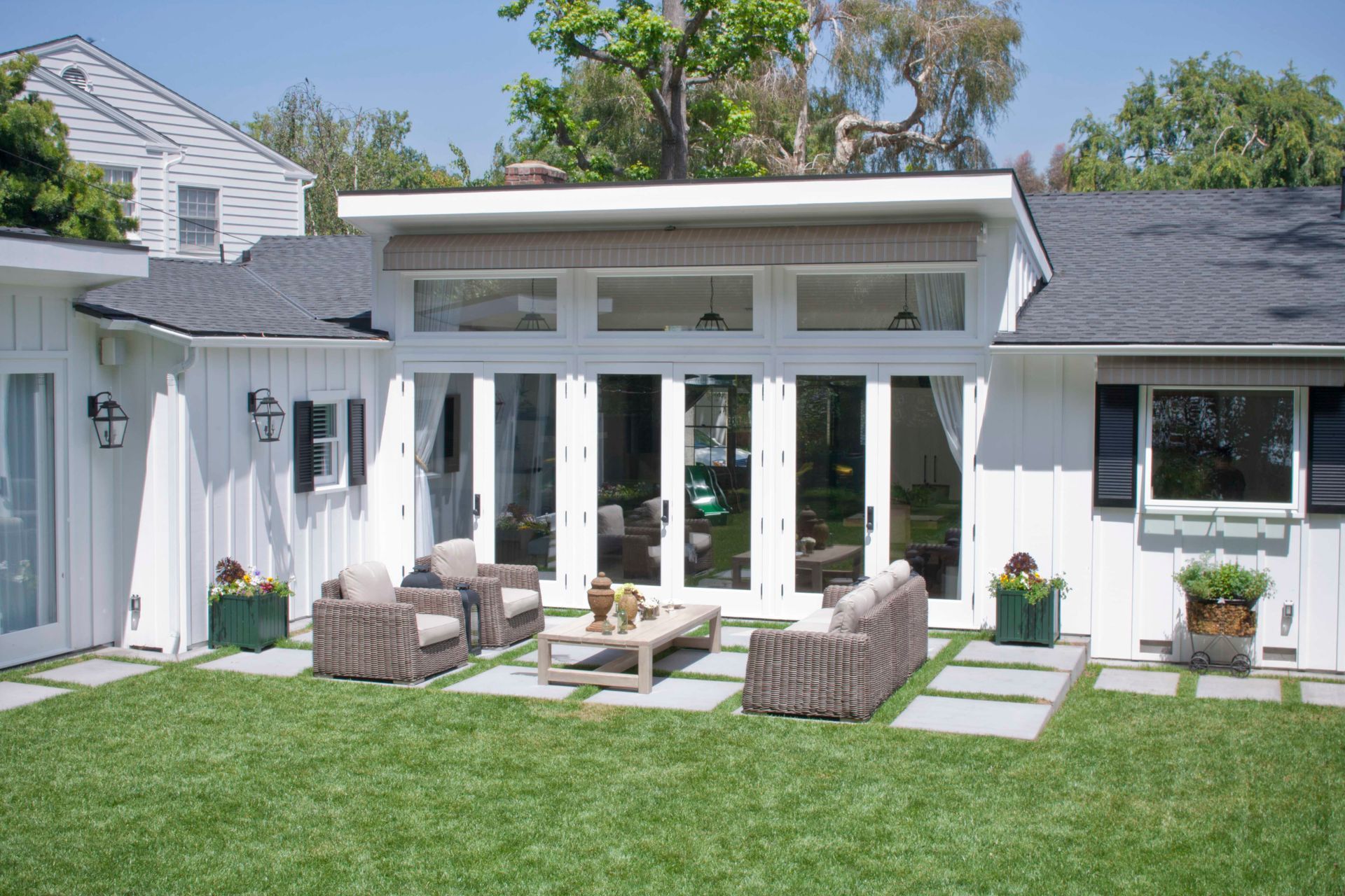A white house with a patio area in front of it.